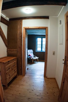 Von der Küche führt der Flur ins Wohnzimmer, zum Einzelzimmer und ins Bad.