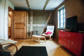 Besonders warmes Flair: Im Wohnzimmer des Appartements „Ueckermünde“ sind die Wände noch naturbelassen.