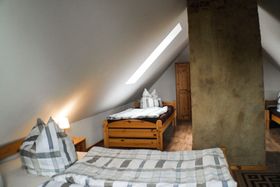 Im gemütlichen Dachzimmer der Wohnung „Ueckermünde“ befinden sich ein Doppel- und zwei Einzelbetten.